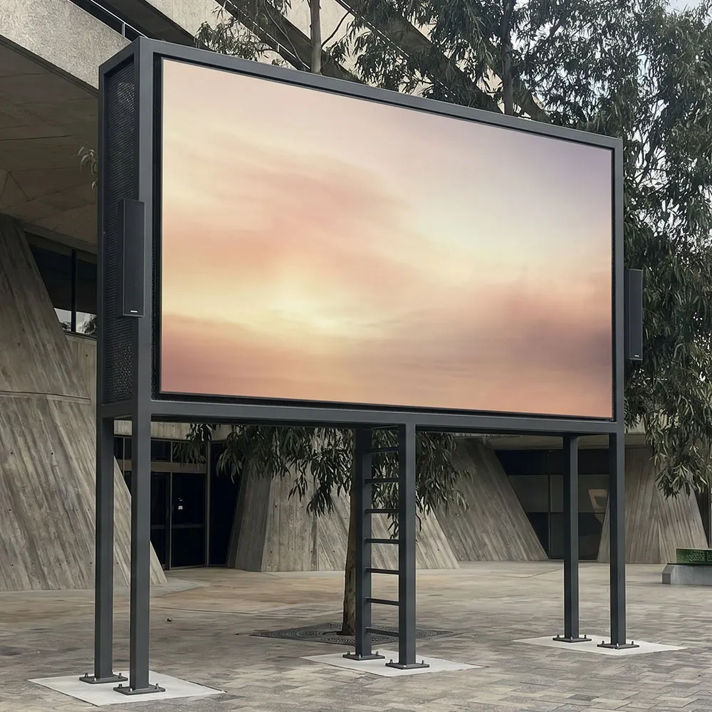 A 7.5m-wide outdoor cinema-grade LED screen on an engineered frame at dusk with a large crowd