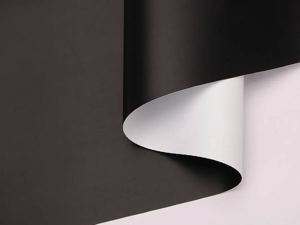 A roll of commercial-grade coated PVC fabric, black on the face and white on the reverse